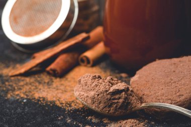 Sıcak çikolata (kakao) arka planda içilir. Tarçınlı ve çırpılmış koyu bir arka planda kakao içeceği. Sıcak kış içecekleri