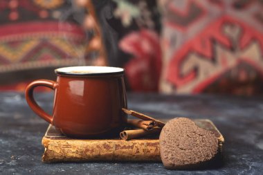 Sıcak çikolata (kakao) arka planda içilir. Tarçınlı ve çırpılmış koyu bir arka planda kakao içeceği. Sıcak kış içecekleri