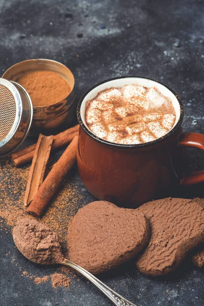 Hot chocolate (cocoa) drink backround. Cocoa drink on a dark background with cinnamon and whipping. Winter hot drinks