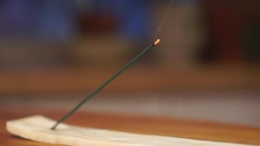 Odadaki ahşap bir masada tütsü çubuğu ve duman. Rahatlama, dinlenme ve sükunet arka planı.