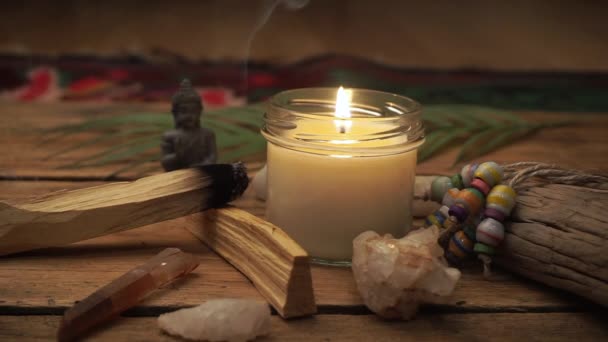 難解なもの、お香や装飾が施された木製のテーブルの上に炎を持つ自家製キャンドル。家庭の快適さ、ヨガ、瞑想、リラクゼーションと休息の概念. — ストック動画