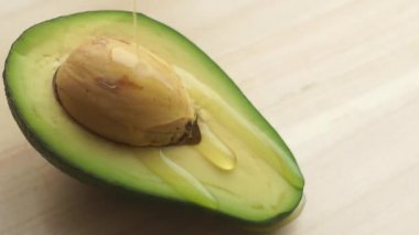 Meyvelerin üzerine avokado ve avokado yağı dökülüyor. Gıda ve kozmetik ürünleri için avokado yağı.