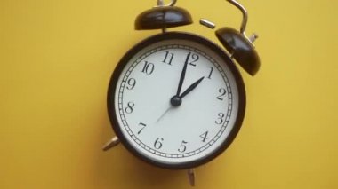 Renkli izole bir arkaplanda çalar saat dönüyor. Zaman, zamanlama ve teslim tarihi kavramı. En küçük sanat