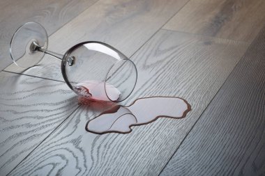 Altüst olmuş kırmızı şarap kadehiyle ahşap zemin. Ahşap kaplamalı yere dökülen şarap (parke) nem korumalı..