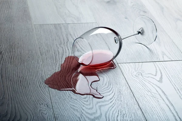 Holzboden Mit Umgekipptem Glas Rotwein Verschütteter Wein Auf Einem Holzlaminatboden — Stockfoto