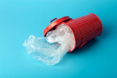 Plastik çöp ve atıklar mavi arka plandaki bir çöp kutusunda. Atık ve plastik tasnif ve geri dönüşüm kavramı