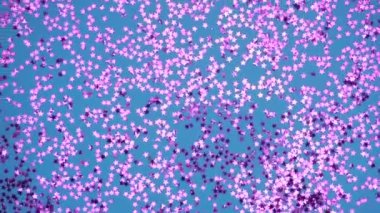 Mavi arka planda dönen pembe yıldızlar parıldıyor. Neşeli, büyüleyici, parlak bir arka plan.