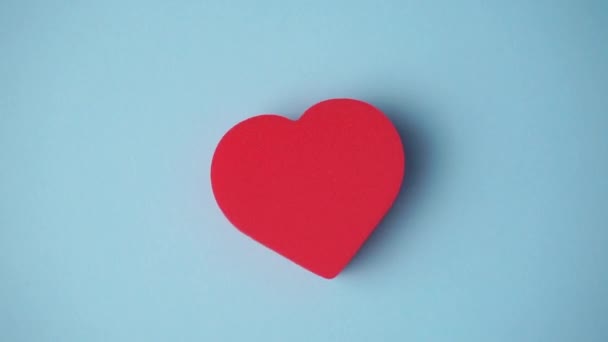 Het rode hart op de blauwe achtergrond. Valentijnsdag, liefde, huwelijk, romantiek concept. Minimale kunst creatieve video met hart — Stockvideo
