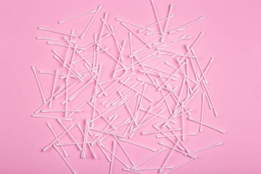 Pembe arka planda plastik temizlik çubukları var. Plastik kirliliği ve hijyen atığı kavramı.