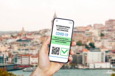 Coronavirus aşı sertifikası ya da gezginler için aşı pasaportu. COVID-19 uluslararası seyahat için akıllı cep telefonu uygulamasındaki e-pasaport. Bulanık tarihi şehir arka planı