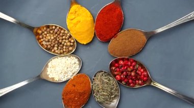 Baharat arka planı. Hindistan ve Asya yemek baharatları kaşıklarda ve karanlık arka planda. Hint mutfağının malzemesi olarak köri, biber, kırmızı biber.