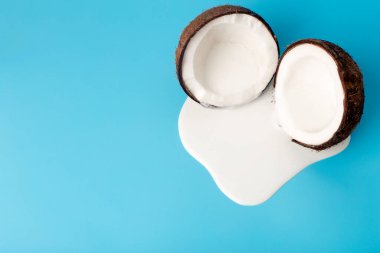 Hindistan cevizi kremalı ya da tereyağlı ve mavi arka planda taze hindistan cevizli. Hindistan cevizinden damlayan beyaz krema suyu.