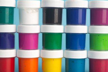 Mavi arka planda farklı renklerde akrilik boya. Resim yapmak için boya.