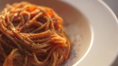 Domates soslu makarna. Domates soslu İtalyan spagetti makarnası mutfak arka planında beyaz bir tabakta döner. İtalyan Mutfağı.