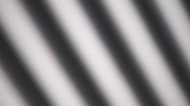 Gölge kaplama efekti arka planı. Güneşli bir günde açık bir duvarda çizgilerin ve çerçevelerin gölgeleri hareket eder..