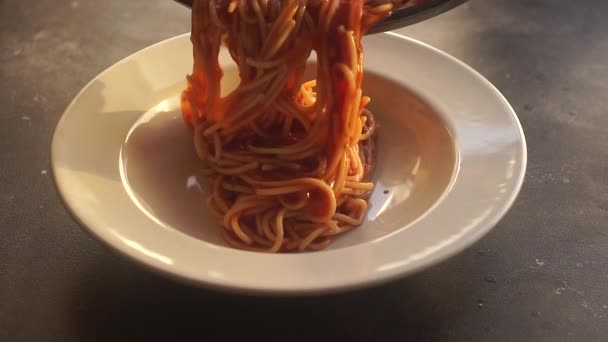 Ζυμαρικά με σάλτσα ντομάτας. Η ιταλική μακαρονάδα ζυμαρικών με σάλτσα ντομάτας σερβίρεται σε πιάτο σε φόντο κουζίνας. Ιταλική κουζίνα. — Αρχείο Βίντεο