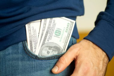 Bir adam elinde nakit Amerikan doları tutuyor. Para, iş, kâr ve geçim konsepti