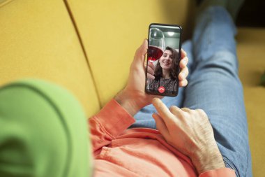 Akıllı telefondan kızı videoya çeken adam. Online randevu, sanal buluşma, internet tarihleri.