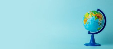 Temiz mavi afişte Dünya küresi. Eğitim, okul, öğrenim ve bilgi geçmişi kavramı.