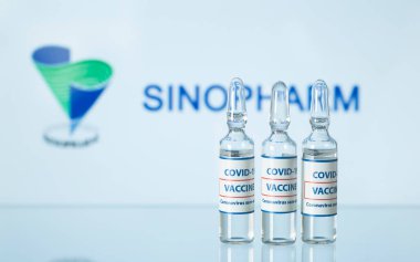 COVID-19 'a karşı Çin aşısı kavramı. Sıvı içeren cam şişeler. Tıbbi cam sehpanın üzerinde koronavirüs aşısı olan ampuller. Seçici odaklanma. New York, ABD - 14 Aralık 2020