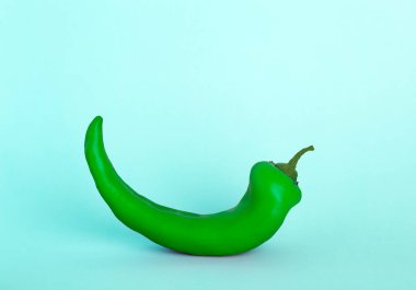 Mavi arka planda yeşil kırmızı biber. Asgari gıda sebze konsepti