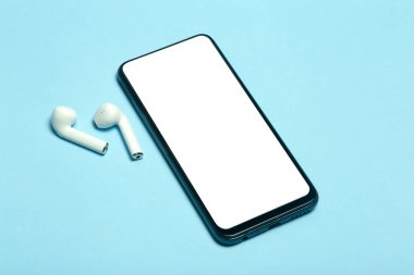 Kulaklıklı, renkli bir arkaplanda akıllı telefon boş ekranı. 