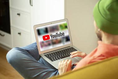 Evde dizüstü bilgisayarla çalışan bir adam. Boş dizüstü bilgisayar ekranı. Ev kavramından uzak çalışma