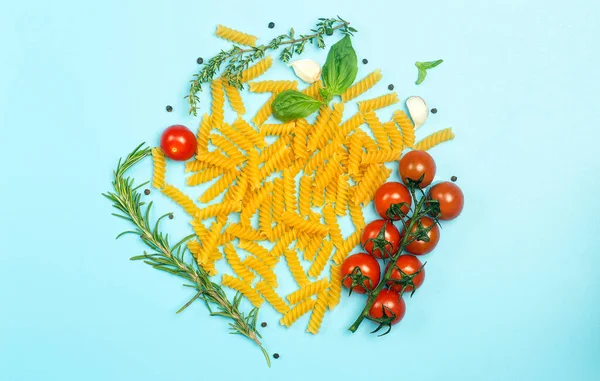 Massa fusilli crua com tomate, ervas e manjericão. Massa italiana com ingredientes nas cores da bandeira italiana. — Fotografia de Stock