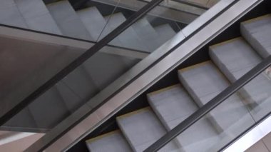İş merkezinde, alışveriş merkezinde ya da havaalanında boş yürüyen merdivenler. Yürüyen merdivenlerin hareketi. Şehirde boş kamusal alanlar ve mekanlar