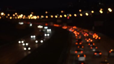 Otobanda gece trafiği sıkışıklığında arabaların bulanık ışıkları. Yukarıdan trafik ışıkları