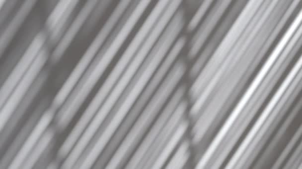 Efecto de superposición de sombras. Persianas de bambú borrosas rayas de sombra en la pared de luz blanca en un día soleado — Vídeos de Stock