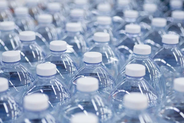 Botellas de agua en el supermercado. Envases de agua potable limpia en botellas de plástico en el mostrador de la tienda. —  Fotos de Stock