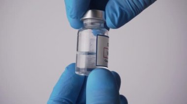 Coronavirus aşısı bir tıp laboratuarındaki bir doktorun elinde. Aşı, koronavirüs salgınından korunma.