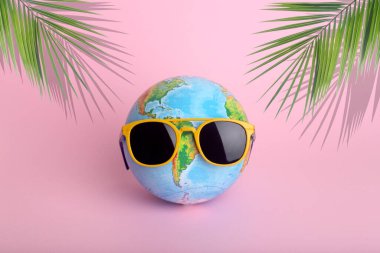 Seyahat yaz konsepti. Renkli arka planda güneş gözlüğü takan bir dünya. Güneş, tatil ve turizm yaratıcı fikir.