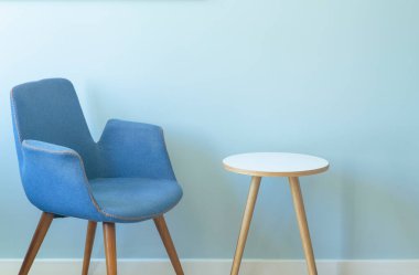 Oda içi boş duvar, koltuk ve kahve masası. Minimalist İskandinav odası veya ofis iç tasarımı açık renkli mavi renkler.