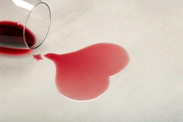 Holzboden mit umgekipptem Glas Rotwein. Verschütteter Wein auf einem Holzlaminat-Parkettboden mit Feuchtigkeitsschutz. — Stockfoto