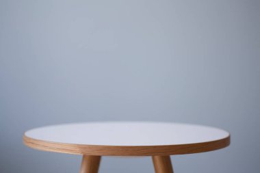 Arka plan masası. İçerideki yuvarlak kahve masası arka planda boş bir duvarın önünde..
