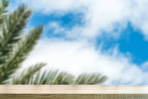 Scrivania tropicale sfondo tavolo. Blurred ramo di palma tropicale sullo sfondo del cielo limpido. — Foto Stock