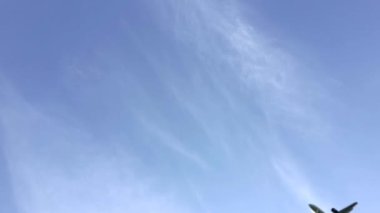 Bulutlu yaz havasında gökyüzünde uçak uçuşu. Uçak beyaz ve gri bulutların arka planına iniyor. Seyahat, seyahat ve tatil konsepti