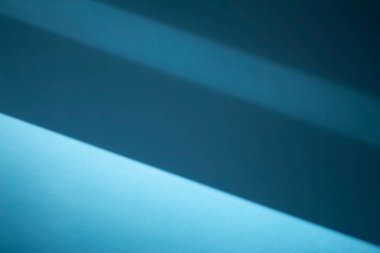 Blue wall shadows background. Sunlight with shadows on clean empty wall in room interior