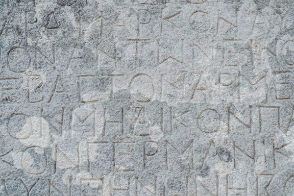 Inscripciones griegas antiguas talladas en la piedra de las ruinas antiguas de una ciudad griega antigua —  Fotos de Stock