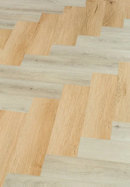 Laminate and parquet with herringbone background. Wooden floor with a chevron pattern in the living room of the designer interior — Stock Photo, Image