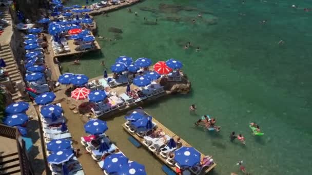 Αττάλεια, Τουρκία - 12 Αυγούστου 2021: Παραλία Μερμερλί στην Αττάλεια της Τουρκίας. Υπέροχη καλοκαιρινή ηλιόλουστη τιρκουάζ παραλία στις ακτές της Μεσογείου. Ανάπαυση, τουρισμός και ταξιδιωτική έννοια. — Αρχείο Βίντεο
