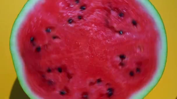 Vattenmelon roterar på en gul minimal färgad bakgrund. Saftigt mogen röd och skär vattenmelon bakgrund. Sommar, frukt, tropik, vitaminkoncept. — Stockvideo