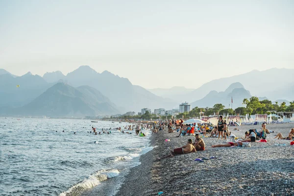 アンタルヤ,トルコ- 12 8月2021:アンタルヤでKonyaaltiビーチ.暖かい晴れた夏の天気で地中海の長いトルコのビーチ。海辺のリゾートで観光客の残りの部分 — ストック写真