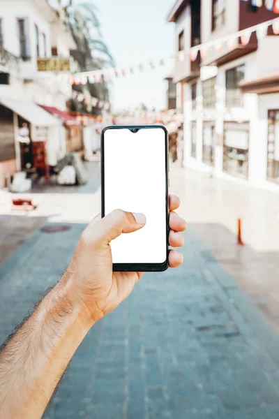 Şehirdeki bir turist sokağının arka planındaki boş ekran akıllı telefon. Turistler ve seyahat için başvurular ve İnternet. — Stok fotoğraf