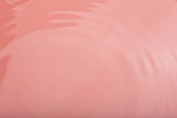 Água tranquila ondulação fundo. Textura de água, círculos e bolhas em uma superfície rosa líquida. Produtos cosméticos e conceito de design plano — Fotografia de Stock