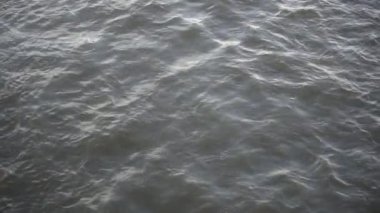 Okyanustaki ya da yukarıdaki siyah dalgalı karanlık su. Karanlık, kasvetli deniz. Su yüzeyinde bulutlu dalgalar ve dalgalar var..