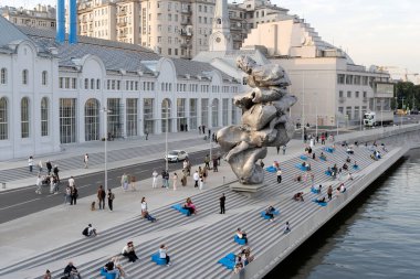 Moskova, Rusya - 31 Ağustos 2021: Moskova 'daki Bolotnaya setinde Urs Fischer Büyük Çamur 4' ün heykeli. Yaz aylarında tatilcilerle şehir manzarası ve toprak seti