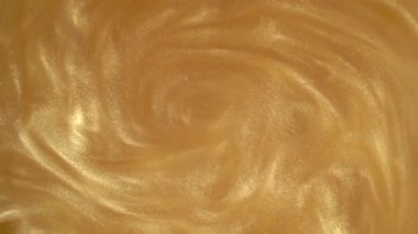 Altın parıltısı soyut arka plan. Parlak sıvı altın boya yavaşça yüzeye akar. Tatiller, yeni yıl, moda, soyut sanat konsepti videoları